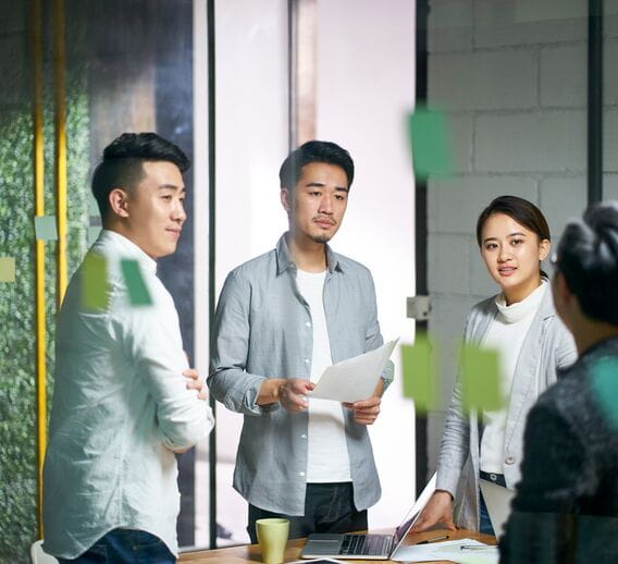 A group of Asian business colleagues brainstorming in a conference room