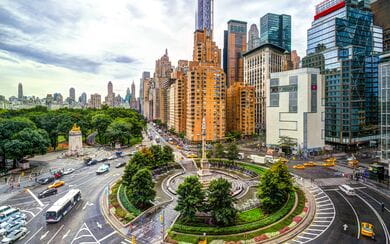 A scenic roundabout in Manhattan with large corporate buildings in the backround