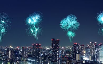 The Tokyo skyline at night with blue fireworks across the sky