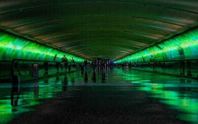 Lime green lights reflecting in an X pattern down a dark tunnel