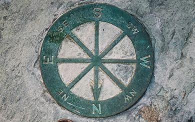 Green compass embossed in outdoor pavement