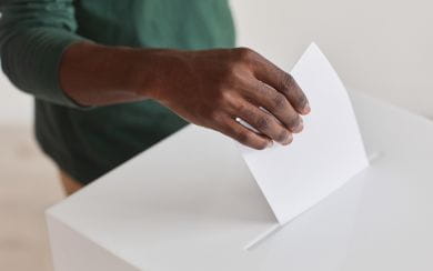 A person submitting their voting ballot