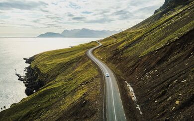 A scenic road winding down the side of a coastal mountain