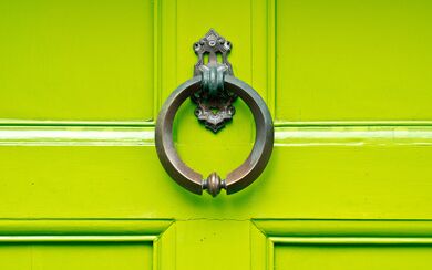 A lime green door with a decorative knocker