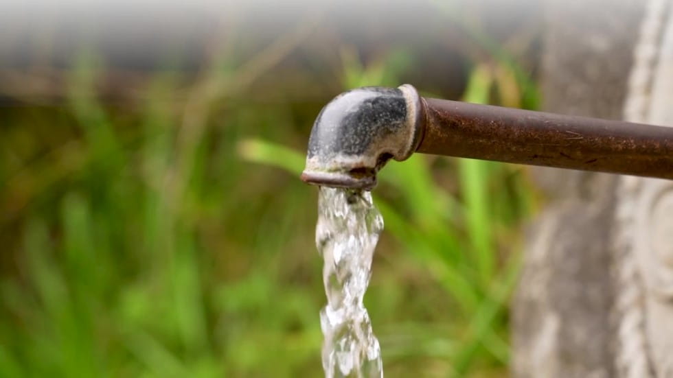 Irrigation water flowing from a pipe in slow motion representing the Hogan Lovells partnership with WaterAid to provide access to clean water for those in need