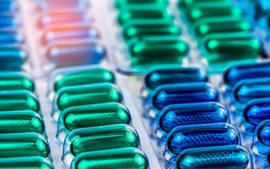 Blue and green soft gel capsule pills symbolizing the pharmaceutical industry and drug production for life sciences and healthcare