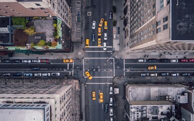 Fifth Avenue in New York City as seen from above, with taxis seen in traffic, buildings, roads, and streets