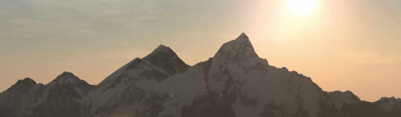 The sun rising over mountain peaks, casting a warm glow